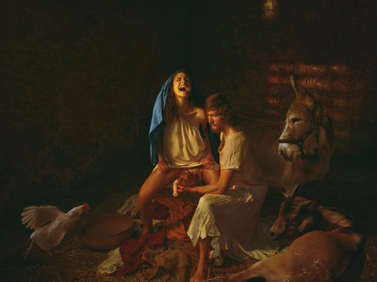 Every year we celebrate a natural birth, a story that takes place in the most primitive surroundings. Mary, giving birth to the Son of God in a stable, that infamous image portrayed countlessly in culture, familiar to even the non-religious. Yet how is it that beyond Julius Garibaldi’s painting of 1891 where Mary and Joseph are slumped in raw exhaustion, we have never seen a ‘real’ depiction of birth biology, particularly of Mary in upright, ecstatic primal instinct that such an environment would have helped facilitate? Risking controversy to use universal characters to portray the ultimate ‘birth undisturbed’, amongst other mammals in a dim and lowly environment, suggests to modern woman that often in birth, less is more. The ideal of course lies really in the balance of nature and medicine, but to depict Mary in the powerful moment of bringing Christ Earthside, into the calm and steady hands of an actively participating Joseph, protests any notion that the humbling, creative power of woman is anything but as awe-inspiring as the creative hand of God himself.